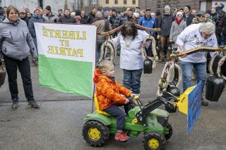 Les paysans ont manifesté avec des cloches et des drapeaux cantonaux. KEYSTONE/PETER SCHNEIDER